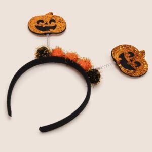 Halloween hairband with two smiling pumpkin decorations and fluffy pom-poms, perfect for festive party looks.